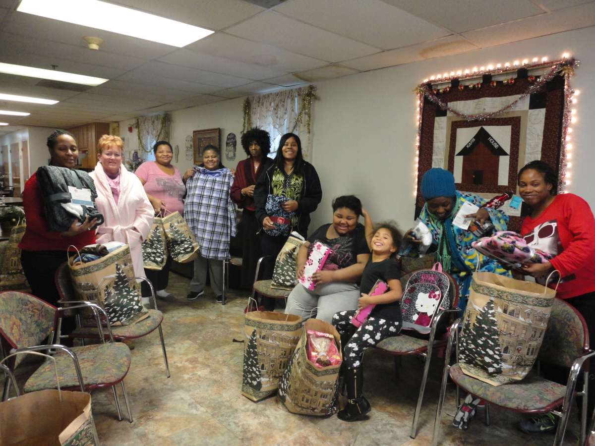 Women receiving Christmas gifts at the Karis Home