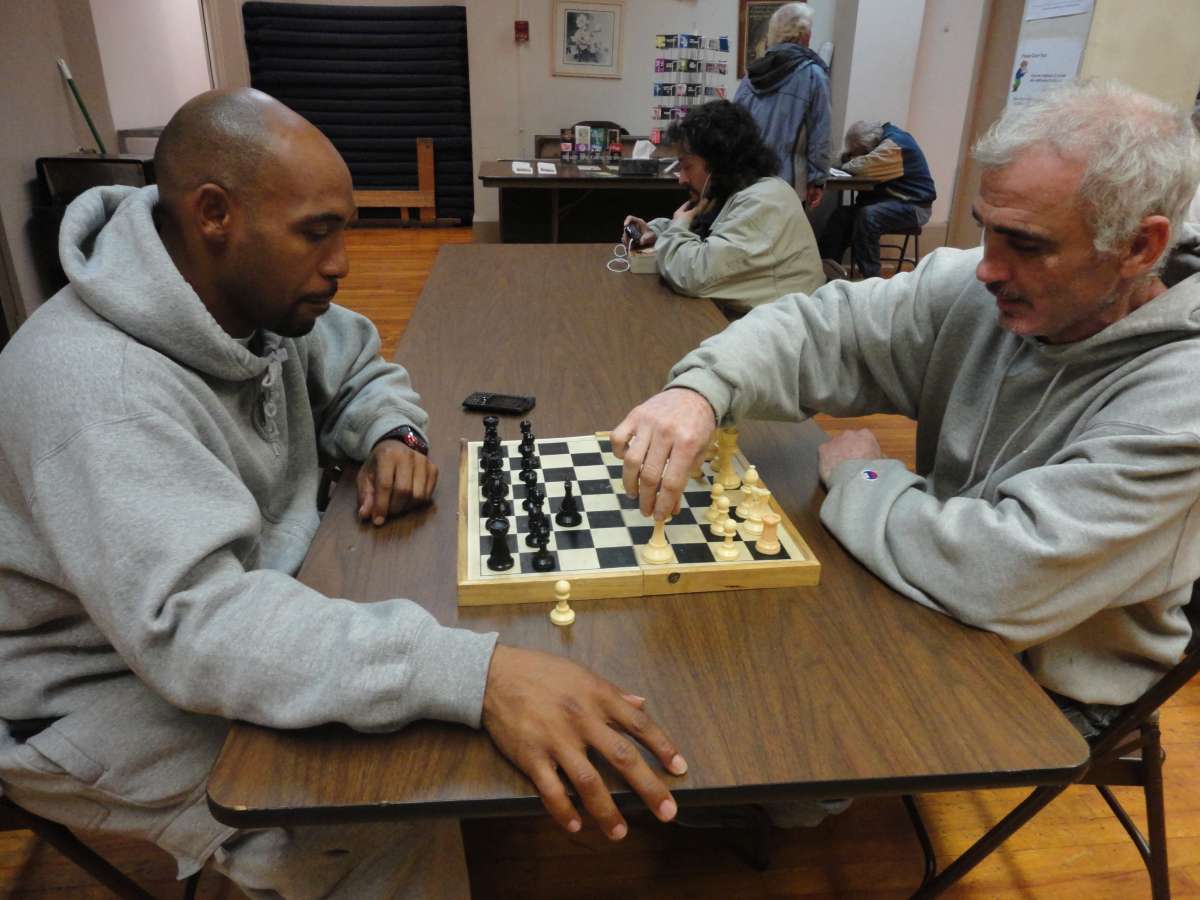 Two men play chess in the recreation center
